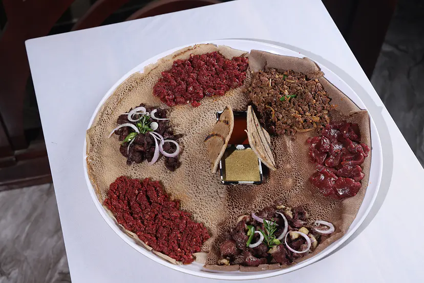 ክትፎ፣ ቁርጥ፣ ጥብስና አይብ በእንጀራ ላይ የቀረበበት የጋራ ገበታ